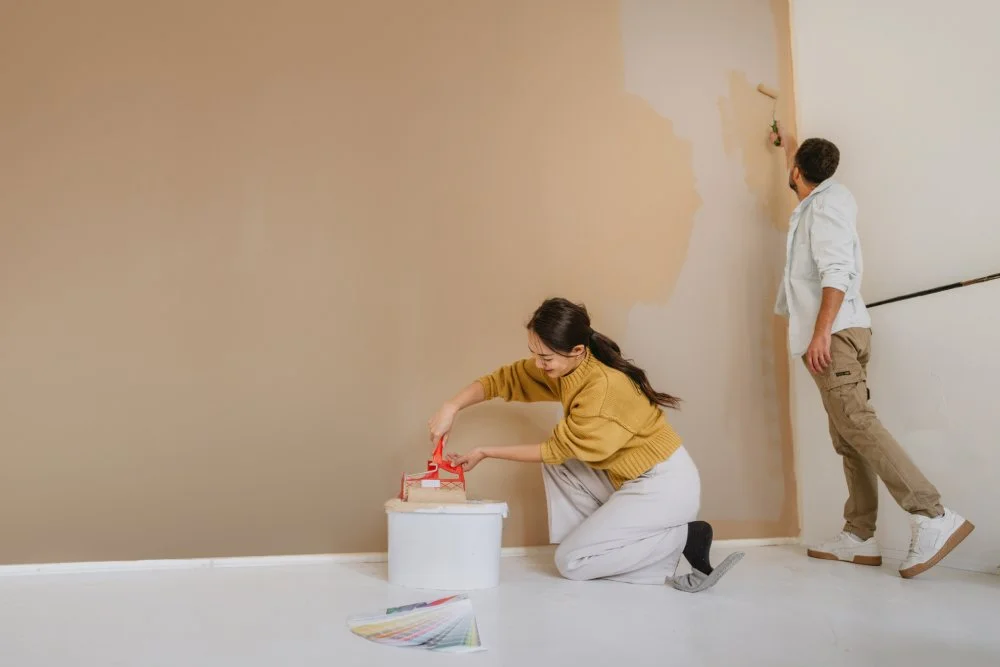 Paar, das während der Renovierung seines Hauses gemeinsam eine Wand streicht